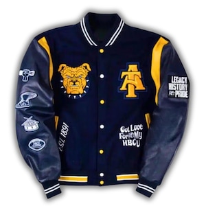 Pode incluir: Uma jaqueta universit&aacute;ria azul-marinho com mangas amarelas e acabamento listrado branco. A frente apresenta um patch de bulldog amarelo, um logotipo AT e o texto EST. 1891 e Got Love For My HBCU. As mangas t&ecirc;m patches, incluindo um punho e tambor.