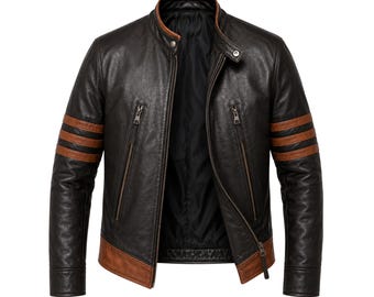 May include: Black leather jacket with brown accents on the sleeves and hem. The jacket features a stand-up collar, a front zipper closure, and two zippered pockets. The sleeves have three brown stripes. The jacket is open, revealing a black interior lining.