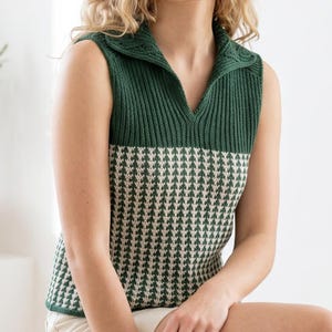Può includere: Un top senza maniche in maglia verde e crema, con colletto. La parte inferiore presenta un motivo a pied-de-poule, mentre la parte superiore è verde unito. Il colletto ha una texture a coste.