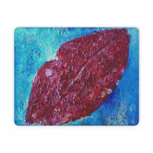 May include: A rectangular mousepad featuring an abstract painting of a pair of red lips against a textured blue background. The lips are rendered with thick brushstrokes, creating a tactile appearance.