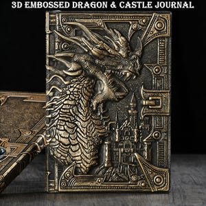 May include: A 3D embossed journal featuring a dragon and castle design. The cover is a dark bronze colour with detailed embossing. The dragon is the central focus, with a castle depicted in the background. The text "3D EMBOSSED DRAGON & CASTLE JOURNAL" is at the top.