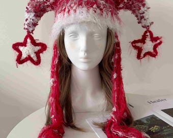 May include: A red and white fuzzy jester-style hat with two long, pointed side extensions. Each extension features a dangling star-shaped ornament at the end. The hat is crafted from a textured, yarn-like material with small white star accents.