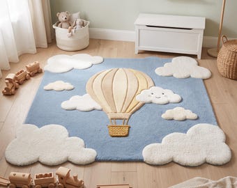 Può includere: Un tappeto rettangolare con sfondo azzurro, una grande mongolfiera beige al centro e diverse nuvole bianche e soffici. Una nuvola presenta un semplice volto ricamato. Il tappeto ha una superficie testurizzata e morbida su tutta la sua estensione.