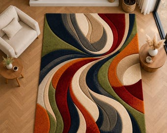Puede incluir: Una alfombra grande y colorida con un diseño abstracto y fluido. La alfombra presenta bandas curvas de color naranja, rojo, verde, azul, beige y gris. La alfombra está colocada sobre un suelo de madera y la habitación incluye una chimenea y muebles.