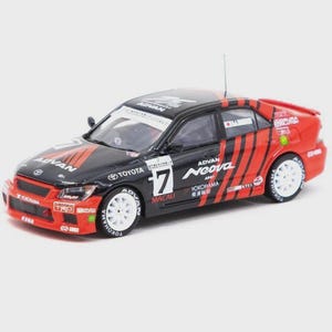 Peut inclure: Modèle réduit de voiture de course Toyota noire et rouge avec des roues blanches. La voiture présente les logos "ADVAN" et "Neova", le numéro "17" et le mot "MACAU". Elle a une petite antenne.