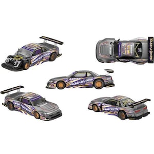 Op de afbeelding: Een verzameling van vijf aanzichten van een zilveren gegoten modelraceauto met paarse en gele grafische stickers, een grote achterspoiler, goudkleurige wielen en zichtbare motoronderdelen op het voorste model met de tekst Kando.