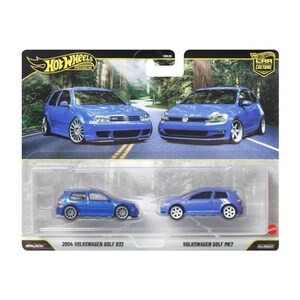 May include: A Hot Wheels Premium two-pack featuring a 2004 blue Volkswagen Golf R32 and a blue Volkswagen Golf MK7. The packaging displays both cars on a road with forest scenery, with the die-cast models visible in a clear plastic blister pack.