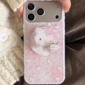 Funda transparente MagSafe con diseño de Hello Kitty en color rosa claro con estampado de varios gatitos, compatible con iPhone 15 / 16 / 17 Pro Max. MagSafe Case + Grip
