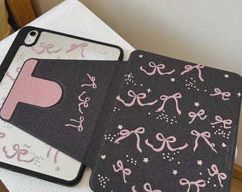 Funda giratoria 360° para iPad, exterior negro con un bonito lazo rosa y estampado de estrellas en el interior. Incluye soporte para iPad 11 / Air 6 / Mini 7 / 10.ª generación.