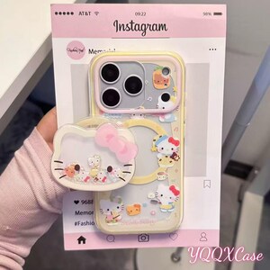 May include: A clear phone case with a yellow border, featuring Hello Kitty and other cartoon characters. The case has a pop-up grip shaped like Hello Kitty's face with a pink bow. The Instagram interface is visible in the background.