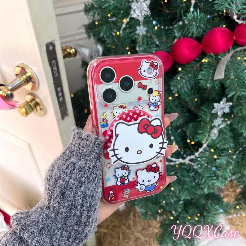May include: A clear phone case with a red border and a Hello Kitty design. The case features a pop-up grip with a Hello Kitty face and other Hello Kitty characters. The case has a red and white checkered pattern and the text "YQQXCase".