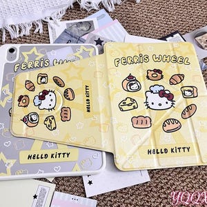 Puede incluir: Una funda para tableta Hello Kitty de color amarillo claro con un diseño de Ferris Wheel. La funda presenta un patrón repetido de estrellas e ilustraciones de alimentos, incluyendo pan, pasteles y queso. El texto "Hello Kitty" se muestra en la funda.