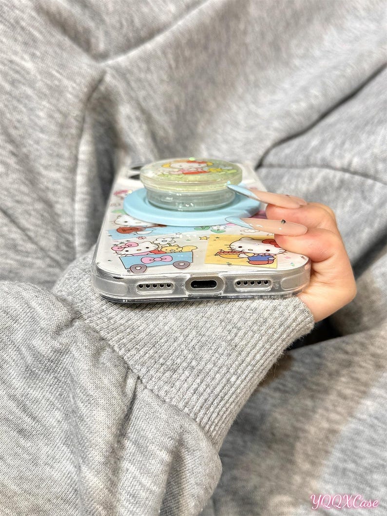 Puede incluir: Una funda transparente para tel&eacute;fono con un dise&ntilde;o de dibujos animados y un soporte para tel&eacute;fono de color azul claro. La funda presenta un patr&oacute;n colorido con personajes de dibujos animados. El soporte tiene una parte superior transparente con una imagen de dibujos animados.