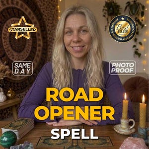 Puede incluir: Una persona de cabello rubio largo con una camisa morada de manga larga sentada ante una mesa de madera con cartas de tarot, dos velas de cera de abeja encendidas, una esfera verde, un racimo de cristales morados y un cristal rosa grande.