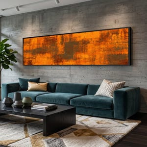 May include: An abstract orange and brown painting in a black frame hangs above a teal sofa. The living room features a black coffee table, decorative vases, and a patterned rug. A large potted plant is visible on the left.
