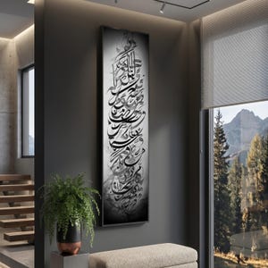 May include: A framed, vertical artwork featuring elegant calligraphy in shades of gray and black. The artwork is displayed on a dark gray wall, with a glimpse of a modern interior and a window offering a view of a mountain landscape.