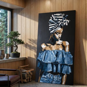 May include: Large canvas artwork depicting a woman against a black backdrop. She is dressed in a blue denim off-the-shoulder top and jeans, with a black and white striped headscarf. The artwork is displayed against a wood-panelled wall.