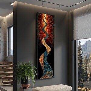 May include: Vertical abstract art piece with a black frame. The artwork features a winding river design in shades of gold, orange, and blue against a black background. The piece is displayed on a gray wall.
