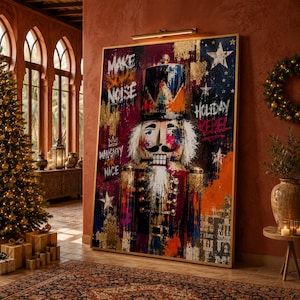 May include: A large rectangular wall art piece featuring a stylized nutcracker with a mustache and white beard. The artwork includes graffiti-style text reading Make Some Noise, Holiday Rebel, and Naughty or Nice, with gold, blue, and red paint splatters.