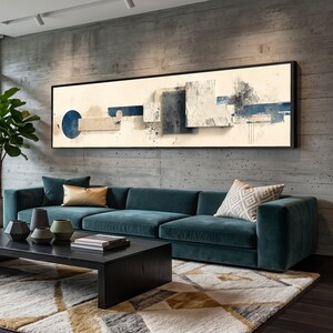 Könnte beinhalten: Ein modernes Wohnzimmer mit einem tealfarbenen Ecksofa, einem schwarzen Couchtisch und einem großen abstrakten Kunstwerk. Das gerahmte Kunstwerk zeigt geometrische Formen in Blau, Beige und Grau. Ein gemusterter Teppich und dekorative Kissen ergänzen den Raum.