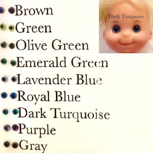 Op de afbeelding: Een kaart met kleurstalen en namen van kleuren, waaronder bruin, groen, olijfgroen, smaragdgroen, lavendelblauw, koninklijkblauw, donkerblauw, paars en grijs. Het woord "Donkerblauw" staat ook boven een poppenhoofd met donkerblauwe ogen.
