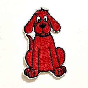 May include: Embroidered patch featuring a cartoon dog in a sitting position. The dog is primarily red with black accents, including its eyes, nose, and collar. The patch has a white border.