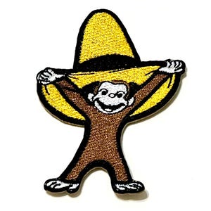 May include: An embroidered patch featuring a brown monkey with white hands and feet, wearing a large yellow sombrero with a black band. The character has a wide smile and is holding the brim of the hat with both hands, outlined in black thread.