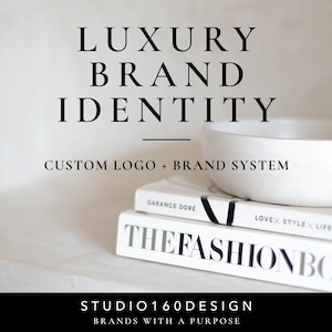 Puede incluir: Un cuenco de cerámica blanca se asienta sobre dos libros apilados, uno titulado THE FASHION BOOK y el otro de Garance Dore. El texto LUXURY BRAND IDENTITY, CUSTOM LOGO + BRAND SYSTEM y STUDIO160DESIGN BRANDS WITH A PURPOSE aparece en negro.