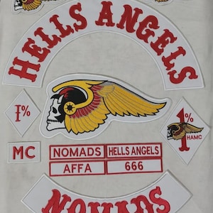 Puede incluir: Parches blancos con texto e imágenes bordadas en rojo. Incluye "HELLS ANGELS" en un diseño curvo, una calavera con alas y la palabra "NOMADS". También incluye los números "666" y las letras "AFFA".