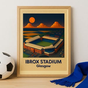 May include: Framed art print of Ibrox Stadium in Glasgow, Scotland, under a sunset sky. A soccer ball and a blue scarf are next to the framed print. The print has the text "IBROX STADIUM Glasgow".