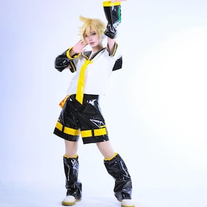 May include: A cosplay outfit featuring a white short-sleeved shirt with a yellow tie, black shorts with yellow accents, and black arm and leg warmers. The ensemble includes a blonde wig styled with spiky layers and a headset accessory.