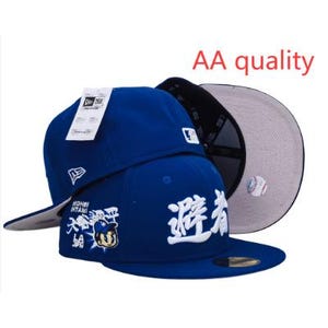 May include: Two blue baseball caps with white embroidered text and logos. One cap has a white tag attached. The underside of the brim is gray. The text "AA quality" is in red.
