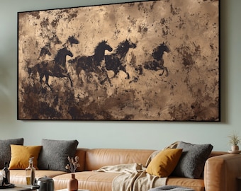 May include: Large rectangular artwork featuring a herd of running horses in silhouette against a textured, golden-brown background. The horses are dark brown and black, creating a striking contrast. The artwork is framed in black.