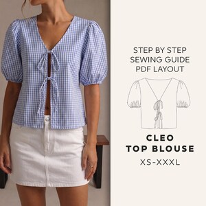 Op de afbeelding: Een blauw-wit geruite Cleo top blouse met een V-hals en striksluiting. De blouse heeft korte, gepofte mouwen. De afbeelding bevat ook een witte spijkerbroekrok en de tekst "STEP BY STEP SEWING GUIDE PDF LAYOUT" en "CLEO TOP BLOUSE XS-XXXL."