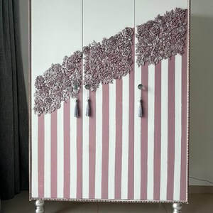 Mobile unico, realizzato a mano, color rosa cipria con pannelli floreali e pomelli in cristallo: un complemento perfetto per interni eleganti.