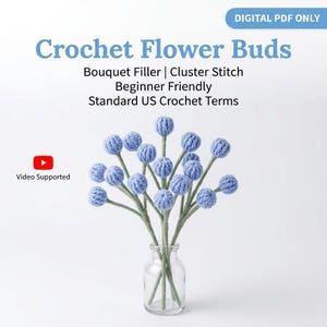 May include: A clear glass vase holds a bouquet of crocheted flower buds. The buds are a light blue color and have a textured appearance. The stems are green, and the text "Crochet Flower Buds" is displayed above the bouquet.