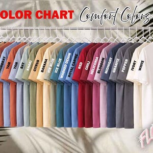 May include: A color chart of Comfort Colors t-shirts in various hues, including black, sandstone, and white. The text "COLOR CHART" and "Comfort Colors" are displayed at the top. Each shirt is labeled with its color name.