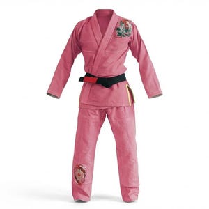 May include: A pink martial arts uniform, comprising a jacket and trousers, with a black belt. The jacket has embroidered details on the shoulder and the trousers have a patch on the knee. The uniform is set against a white background.