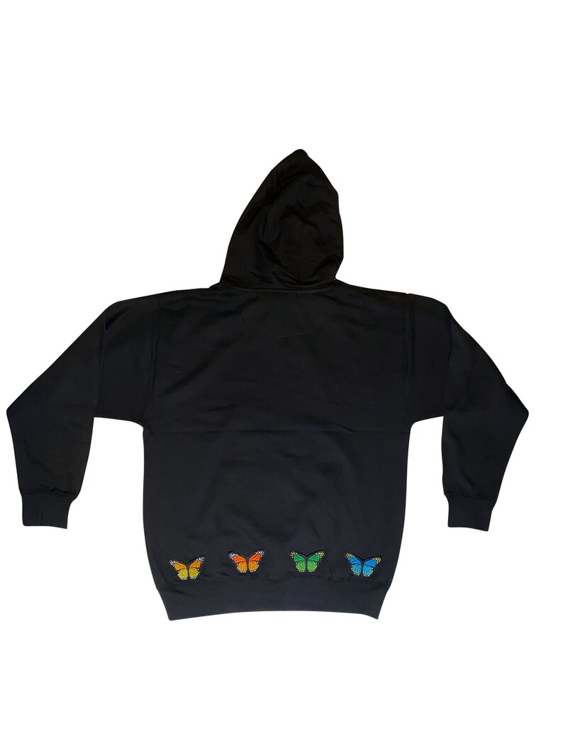 May include: Black hooded sweatshirt with a row of colorful butterfly appliques on the bottom hem.