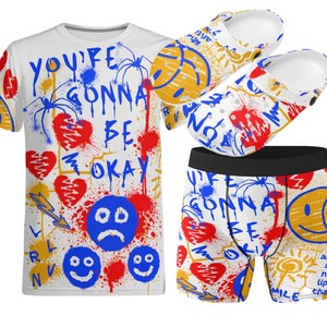 Puede incluir: Una camiseta blanca, unos pantalones cortos de boxeo y un par de zuecos con un estampado de estilo graffiti con corazones rojos, caras sonrientes azules y el texto "You're Gonna Be Okay".