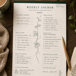 May include: A Weekly Anchor planner sheet with a dark green top border, featuring sections for tasks, meals, and reminders. The paper has a botanical vine illustration in the center, handwritten text, and checkboxes. It is dated May 19-May 25.