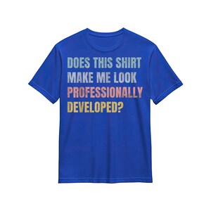 Peut inclure: Un t-shirt bleu roi à manches courtes avec le texte "DOES THIS SHIRT MAKE ME LOOK PROFESSIONALLY DEVELOPED?" imprimé dans une police usée et multicolore avec des lettres blanches, orange clair et jaunes sur la poitrine.