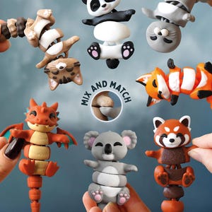 May include: A collection of articulated animal toys, including a panda, fox, red panda, koala, dragon, and cat. The toys are in various colors and have a segmented design, allowing for flexible posing. The image includes the text "MIX AND MATCH".