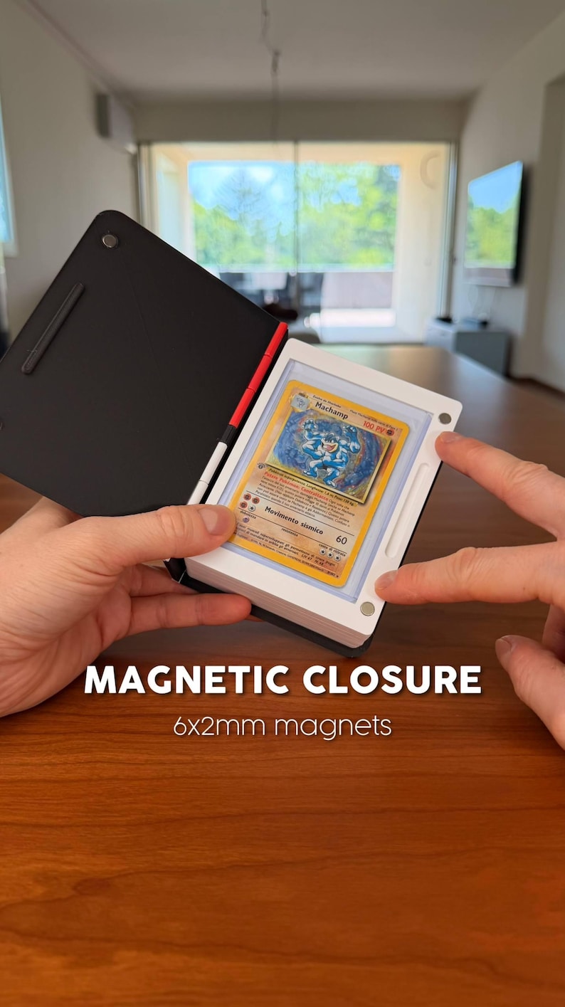 Puede incluir: Un estuche magn&eacute;tico de exhibici&oacute;n en blanco y negro que contiene una carta coleccionable Machamp. El estuche tiene una cubierta negra y un marco blanco con puntos de cierre magn&eacute;tico visibles. El texto dice MAGNETIC CLOSURE 6x2mm magnets.