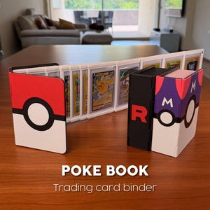May include: A trading card binder with a red and white Pokeball design, a black binder with a red "R", and a purple and white binder with an "M". The binder is open, displaying trading cards. The text "POKE BOOK Trading card binder" is at the bottom.
