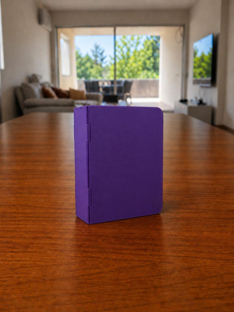 Puede incluir: Un estuche de almacenamiento rectangular de color morado s&oacute;lido con un acabado mate suave y un panel lateral con bisagras. El objeto se mantiene en posici&oacute;n vertical sobre su base, con un dise&ntilde;o limpio sin patrones, texto ni herrajes visibles.
