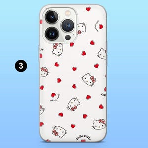 May include: A white phone case featuring a repeating pattern of red hearts and Hello Kitty character illustrations. The case has a clear border and a camera cutout. The words "Hello Kitty" are printed on the bottom.