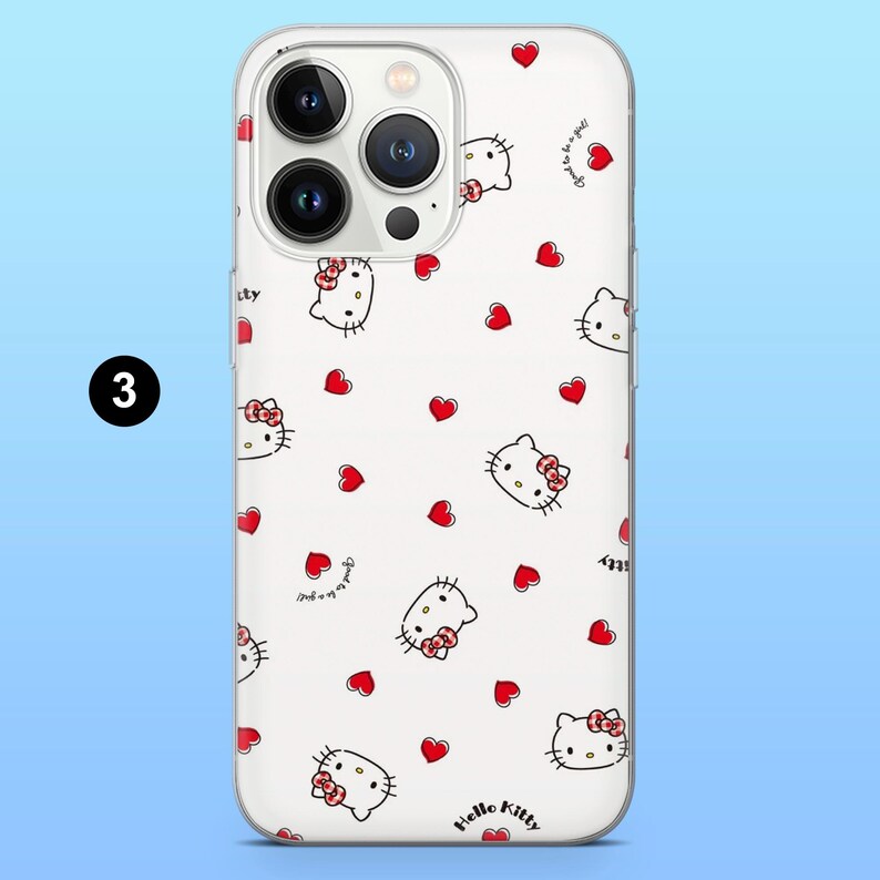May include: A white phone case featuring a repeating pattern of red hearts and Hello Kitty character illustrations. The case has a clear border and a camera cutout. The words "Hello Kitty" are printed on the bottom.