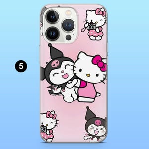 May include: A pink phone case featuring cartoon characters. The case has a light pink background with illustrations of Hello Kitty and Kuromi. Hello Kitty is wearing a pink bow and Kuromi is wearing a black jester hat.