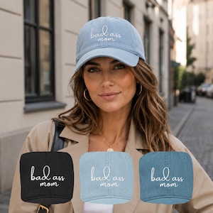 Può includere: Cappellino da baseball in denim azzurro con la scritta ricamata "bad ass mom". L'immagine mostra anche tre cappellini da baseball aggiuntivi in denim nero, azzurro e blu scuro, ciascuno con la stessa scritta.